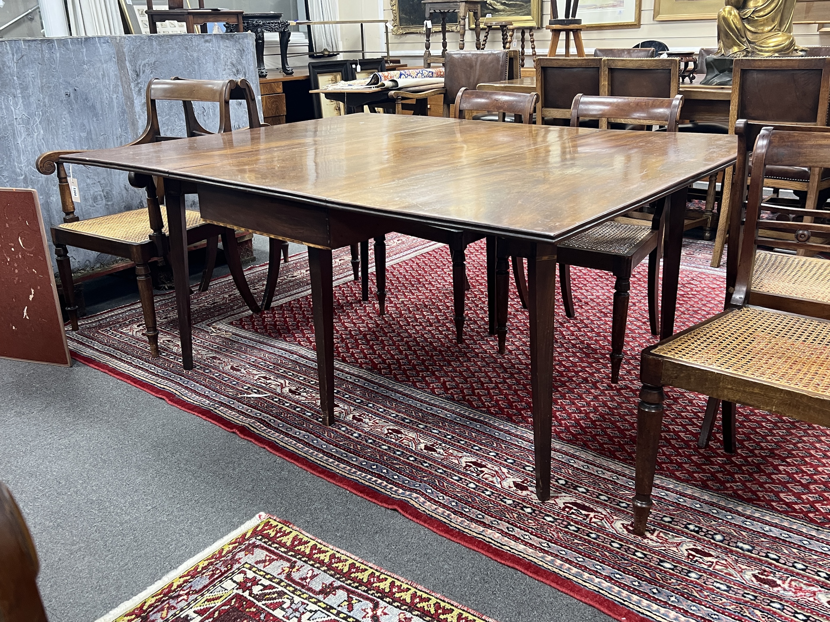 A George III mahogany drop leaf extending dining table on square tapered legs, 165cm extended, depth 130cm, height 74cm